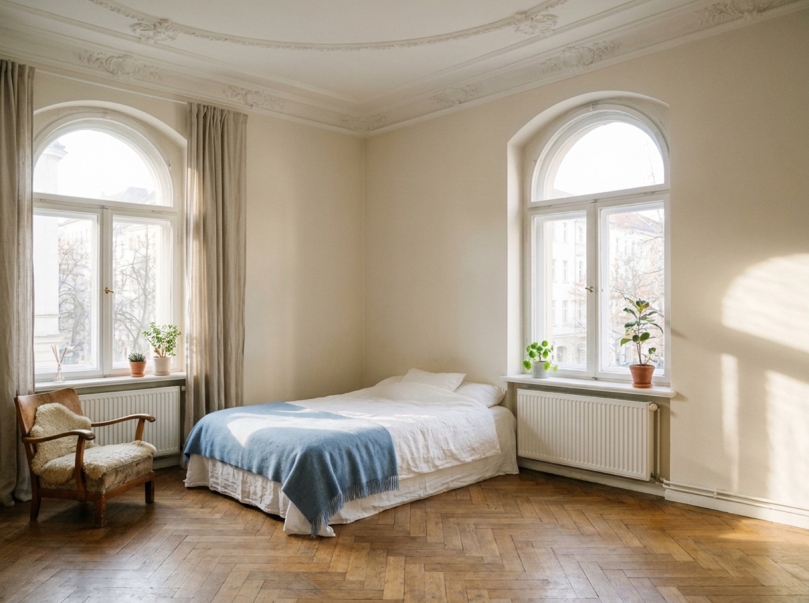 Corner Room — bright bedroom with arched windows and small armchair